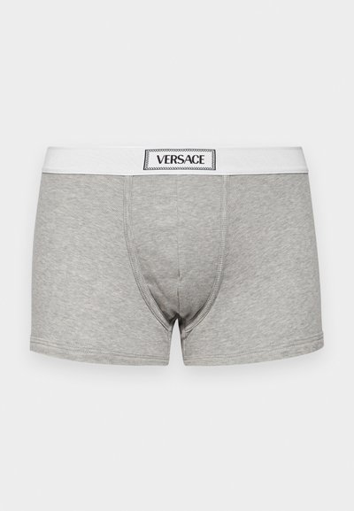 Boxeri gri din material texturat, având o bandă elastică albă inscripționată "VERSACE."