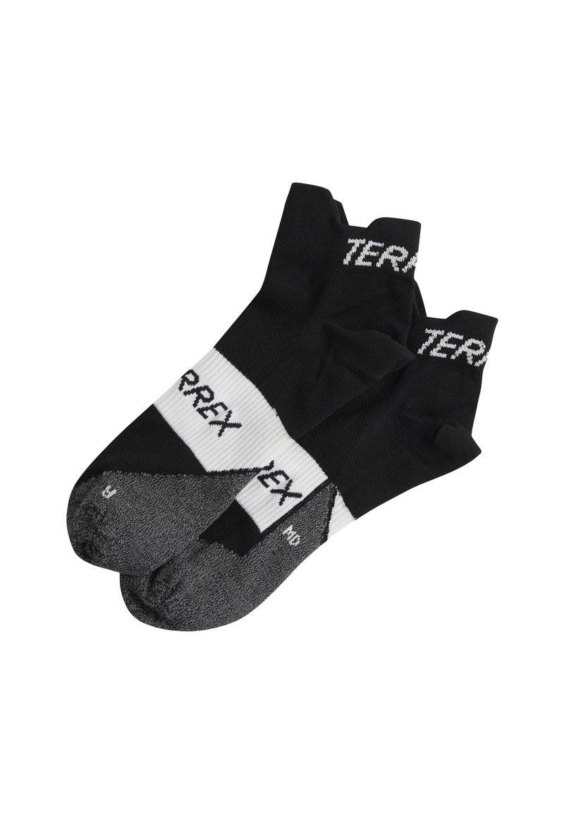 Calcetines deportivos negros con la marca blanca "TERREX", que presentan un puño acanalado, puntera reforzada y un patrón texturizado en la suela.