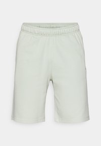 Light green cotton shorts with an elastic waistband, straight cut, and subtle stitching details. Mid-thigh length without pockets.