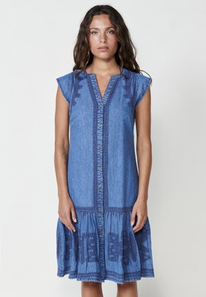 Džínové šaty s krátkými rukávy v podobě cap sleeves, zapínáním na knoflíky vpředu a dekorativní výšivkou podél živůtku a lemu v modré barvě.