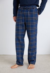 Pantaloni scurți de pijama în carouri albastre, dintr-un material moale, având un cordon la talie, buzunare laterale și accente albe în modelul în carouri.