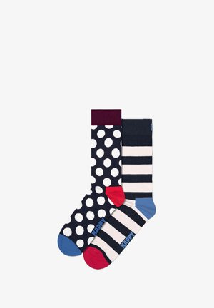 Navy-Socken mit einem großen weißen Punktemuster und einem burgunderfarbenen oberen Teil auf einer Socke, kombiniert mit navy- und cremefarbenen Streifen auf der anderen, mit farbigen Zehenakzenten.