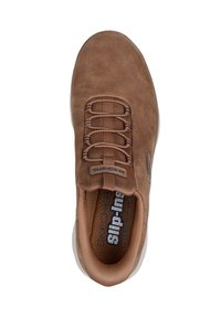 Chaussure slip-on en daim marron avec six lacets élastiques, semelle intérieure rembourrée et semelle en caoutchouc blanche. Présente la marque Skechers à l'intérieur.