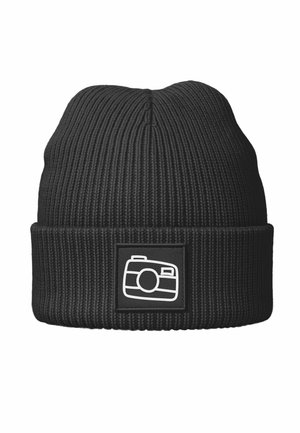 Black knitted beanie with a ribbed texture, featuring a rectangular black patch displaying a white camera icon.