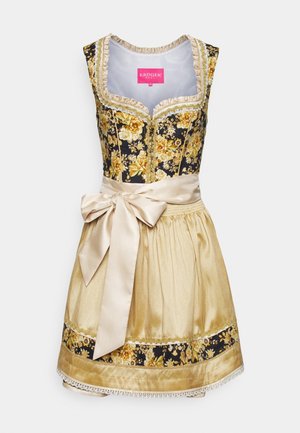 Traditionel ærmeløs dirndl kjole med sort og guldfarvet blomsterkorsage, beige forklæde bundet med en stor sløjfe og matchende nedre kant på nederdelen.
