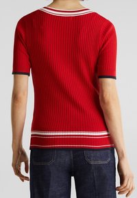 Top de punto acanalado rojo de manga corta con detalles a rayas blancas y marinas en el cuello y el dobladillo, que presenta una silueta ajustada.