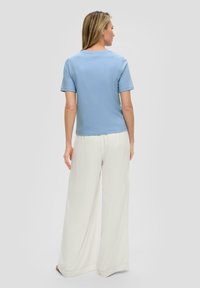Light blue short-sleeve top and white wide-leg pants. The top features a simple rounded neckline, and the fabric appears soft and smooth.