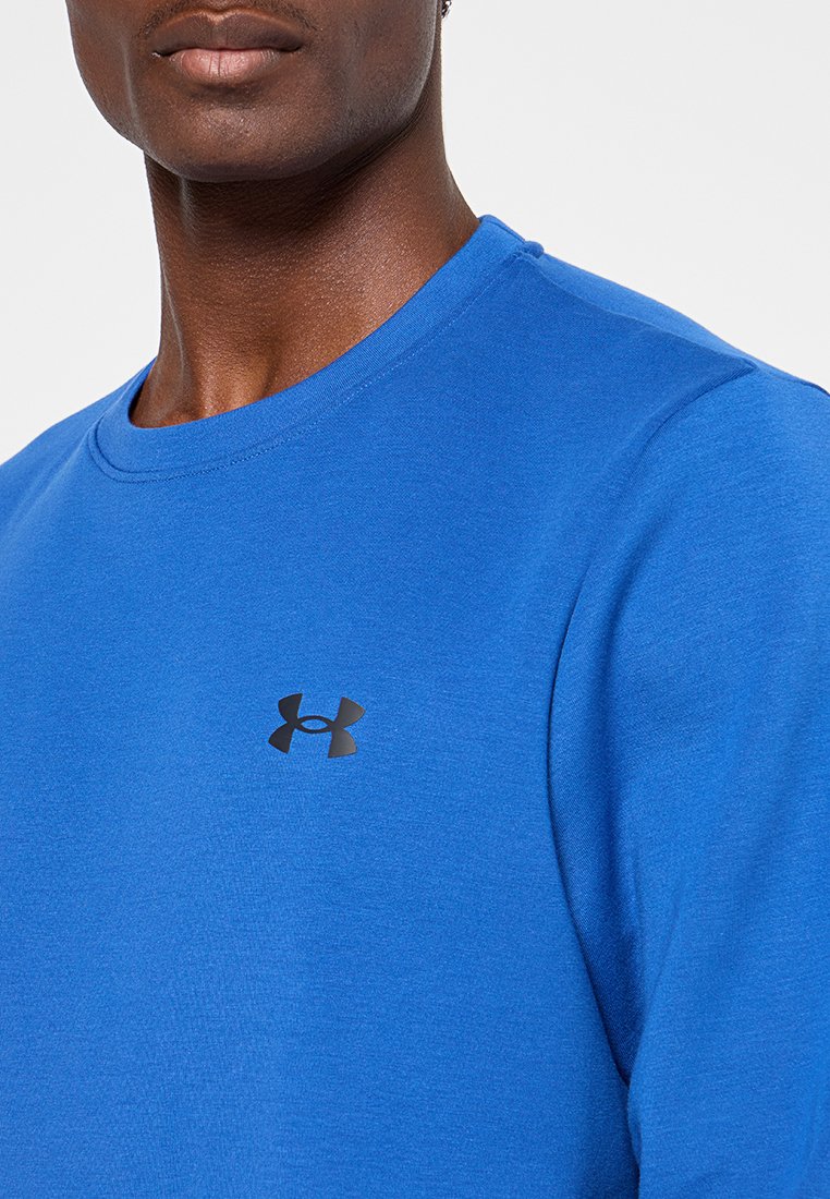 Blue sweatshirt made of cotton blend with a round neckline and short sleeves. Features a black Under Armour logo on the chest.