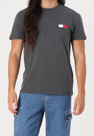 Grå bomulds t-shirt med et lille flerfarvet logo-patch på brystet, rund halsudskæring og korte ærmer. Simpelt design.