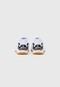 White athletic shoes with a mesh upper, black accents, and a gum rubber sole. Features a logo at the heel and a contoured design.