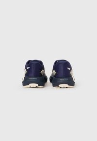Marineblauwe sportschoenen met een gestructureerd mesh bovenwerk, energisch schuim middenzool, rubberen buitenzool en contrasterende witte accenten op de hiel en zijkant.