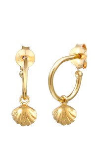 Orecchini a cerchio in oro con un ciondolo a forma di conchiglia. La conchiglia lavorata a texture pende da un cerchio liscio e arrotondato, mettendo in risalto il metallo lucido.