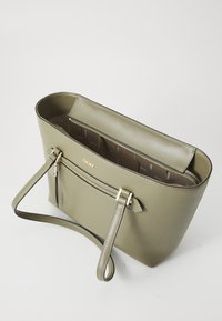 Borsa a spalla verde oliva realizzata in materiale sintetico, con una parte superiore con zip, tasca frontale con dettagli in oro e una texture liscia.