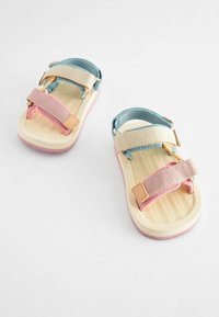 Zwei mehrfarbige Sandalen mit einer hellbraunen Sohle, blauen und rosa Stoffriemen mit verstellbaren Verschlüssen und strukturierten Fußbetten.
