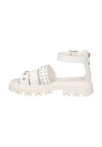 Sandal bianco con suola spessa, multiple cinghie larghe, accenti con borchie e una cinghia alla caviglia regolabile con chiusura a zip.