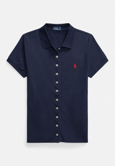 Marineblå poloshirt med knapper foran, korte ermer og en rød logo på venstre bryst. Laget av en strukturert bomullsblanding.