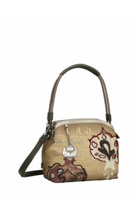 Handtas van lichtbruin leer met een decoratief bloemmotief en metalen accenten. Voorzien van een gebogen handvat en een verstelbare schouderriem.