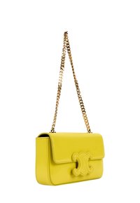 Sac à bandoulière en cuir jaune avec une bandoulière chaîne dorée et un fermoir décoratif sur le rabat avant.