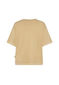 Short-sleeve, loose-fitting t-shirt in light beige, featuring a simple round neck and a smooth, soft texture. Subtle logo tag on side.