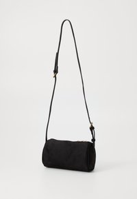 Borsa a spalla in suede nero con forma cilindrica, tracolla regolabile e chiusura con zip. Presenta dettagli in metallo color oro.