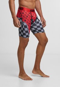Boxer-briefs pour hommes avec un design en damier rouge et noir orné de motifs de crânes, en polyester, et dotés d'une ceinture élastique.