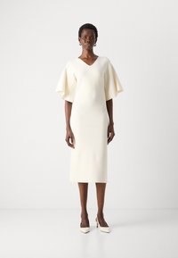Cream-colored midi dress with flutter sleeves and a V-neckline. Made from smooth fabric, featuring a fitted silhouette and minimal design.