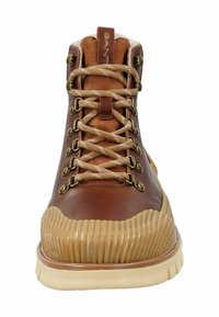 Brązowy skórzany boot z kremową gumową podeszwą, z teksturą żebrowaną, złotymi oczkami i beżowymi sznurowadłami. Logo GANT na języku.