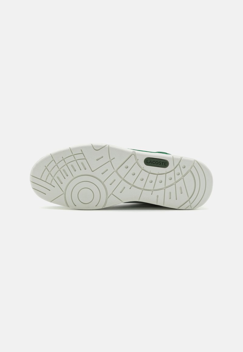 Witte rubberen sneakerzool met een textuurontwerp, met cirkelvormige en lineaire patronen. Opvallende groene branding met 'LACOSTE' detail.