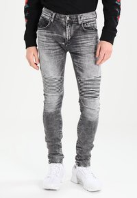 Šedé skinny džíny s horizontálním pruhovaným vzorem na kolenou, s vintage detaily, pěti kapsami a stříbrným kováním.