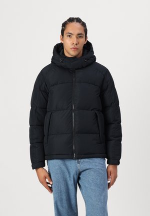 Zwarte pufferjack met een hoge kraag, ritssluiting en een capuchon met trekkoord. Gemaakt van gewatteerde stof, wat zorgt voor een gevoerd uiterlijk en warmte.