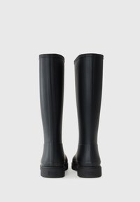 Black rubber knee-high rain boots with a smooth finish, featuring vertical ridges and a rectangular heel, labeled at the back.