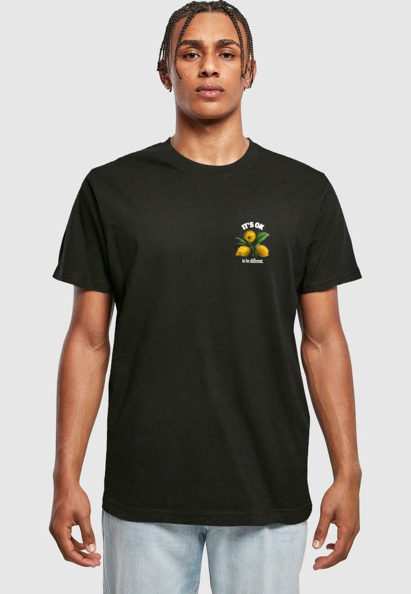 Black cotton t-shirt with short sleeves, featuring a graphic of lemons and text "IT'S OK to be different" on the chest in white and green.