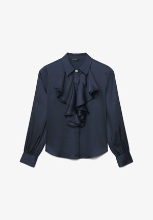 Blouse à manches longues bleu marine avec col pointu, détail volanté à l'avant et bouton bijou décoratif au niveau de l'encolure.