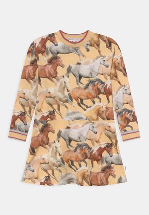 Beige kjole med lange ærmer og et farverigt print af forskellige løbende heste i brune, hvide og grå nuancer.