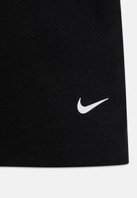 Schwarze Sportshorts mit glatter Textur, versehen mit einem weißen Nike-Swoosh-Logo nahe dem Saum und sauberen Nähten entlang der Kante.