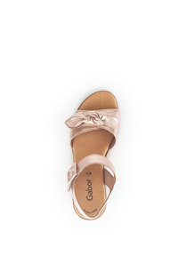 Sandal in oro rosa con una fascia annodata, suola piatta, fibbia regolabile alla caviglia e soletta imbottita. Logo del marchio stampato sulla soletta.