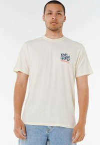 Jasno beżowa bawełniana koszulka z okrągłym dekoltem, z niebieskim i pomarańczowym logo "Rip Curl" na lewej piersi. Krótkie rękawy i luźny krój.
