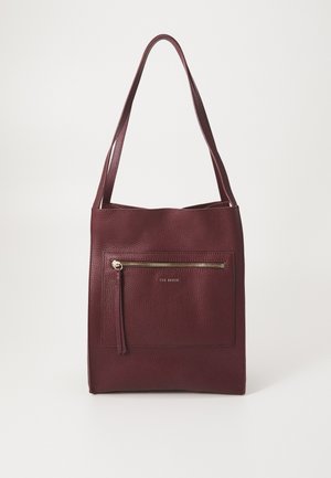 Burgundská kožená taška přes rameno s texturovaným povrchem, obsahující přední zipovou kapsu, prodloužené popruhy a zlatý detail loga.
