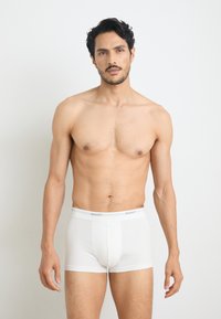 Boxeri scurți din bumbac alb cu o bandă elastică gri pe care este inscripționat logo-ul "GANT". Textură netedă, design ajustat și lungime până la mijlocul coapsei.