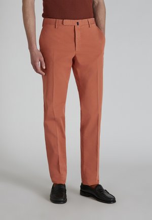 Oranje slim-fit broek van lichtgewicht stof, met een vlakke voorkant, zijzakken en een slank ontwerp. Gepaard met zwarte instappers.
