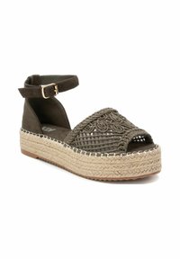 Sandal de esparto en color caqui con punta abierta, parte superior tejida, bordado decorativo, correa al tobillo y suela de cuña envuelta en yute. Forro interior suave.