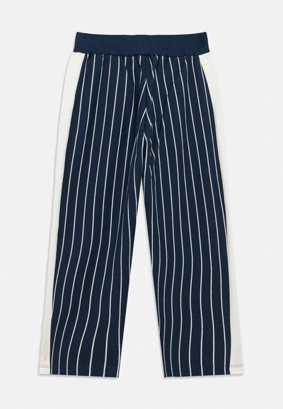 Ναυτικό μπλε παντελόνια με ρίγες, φαρδιά, με λευκές πλευρικές επιφάνειες, ελαστική μέση και απαλή υφή. Κατακόρυφες λευκές γραμμές σε σκούρο φόντο.