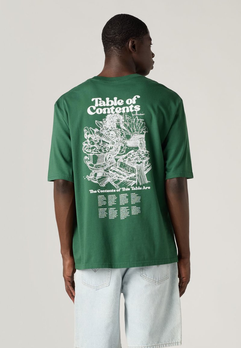 Grünes Baumwoll-T-Shirt mit großem weißem Motiv auf der Rückseite, das den Text "Inhaltsverzeichnis" und verschiedene Lebensmittelillustrationen darunter zeigt.