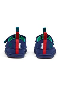 Scarpe per bambini blu navy in camoscio testurizzato, con rivestimento interno verde, linguette per il tallone rosse e accenti del logo su entrambi i lati.