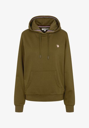 Femme souriante aux longs cheveux blonds portant un sweat à capuche vert olive avec des poches avant et un pantalon assorti sur un fond uni.