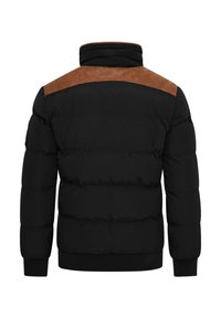 Schwarze Steppjacke mit braunen Leder-Akzenten an den Schultern. Sie hat einen hohen Kragen, gerippte Bündchen und gestickte puffige Abschnitte.