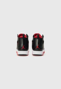 Sorte lærhøye sneakers med røde detaljer, med en hvit midtsåle og gjenkjennelig logo på hælen, som viser et strømlinjeformet design.