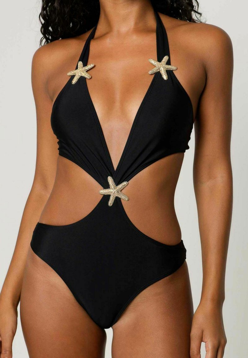Maillot de bain noir une pièce avec un décolleté en V profond, des découpes sur les côtés et des embellissements en étoile de mer dorée aux épaules et à la taille. Texture lisse.