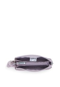 Lila dragkedjefodral för mynt med två fack, silverfärgade dragkedjehandtag och synlig Kipling-märkt etikett inuti.