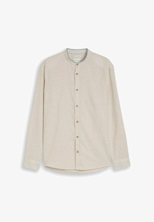 Jasnobeżowa koszula z długim rękawem, stójką i zapięciem na guziki z przodu, prezentowana rozłożona na białym tle.